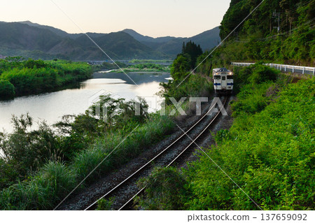 Nichinan Line Kiha 40 running through the fresh greenery of the Hiroto River in Kitago Town, Nichinan City, Miyazaki Prefecture 137659092