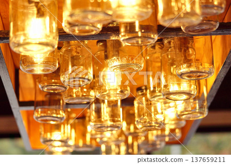 Vintage glass jars on the ceiling in the store in the evening. Light through the glass of the jar.    137659211