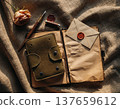 View of worn leather notebook and envelope on fabric surface with rose and pen at afternoon time 137659612