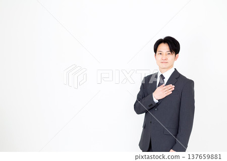 Middle-aged male businessman in a suit holding his hand on his chest 137659881