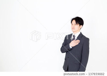 Middle-aged male businessman in a suit holding his hand on his chest 137659882