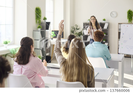 Teen Students Raise Hands in Bright Classroom During Lecture with Teacher Teen Students Raise Hands in Bright Classroom During Lecture with Teacher 137660006