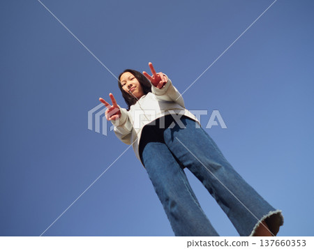 A teenage girl happily playing in a park on a spring afternoon. A teenage girl happily playing in a park on a spring afternoon. 137660353