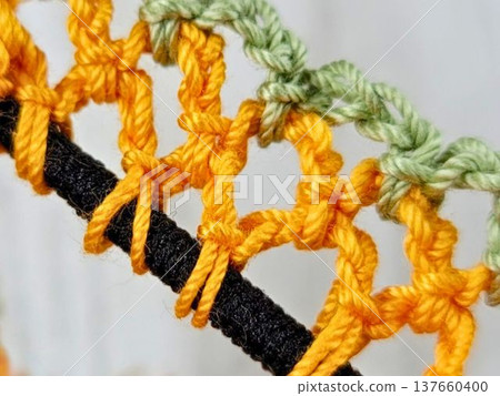 Handmade knitting: Hand-knitted lace scrunchie stitches in orange and muted green. Handmade knitting: Hand-knitted lace scrunchie stitches in orange and muted green. 137660400