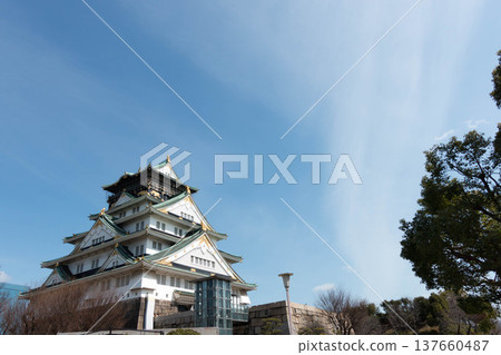 Osaka Castle Tower towering against a blue sky - a background image of a vast sky. Osaka Castle Tower towering against a blue sky - a background image of a vast sky. 137660487