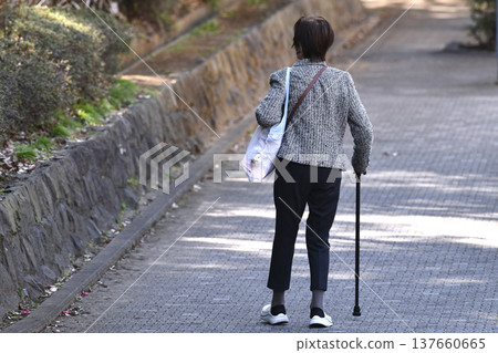 An elderly woman with a cane (wearing a mask) on a hilly sidewalk in Yokohama, Japan... What is life...? = Yokohama City An elderly woman with a cane (wearing a mask) on a hilly sidewalk in Yokohama, Japan... What is life...? = Yokohama City 137660665