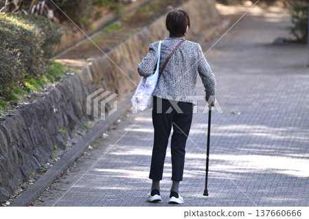 An elderly woman with a cane (wearing a mask) on a hilly sidewalk in Yokohama, Japan... What is life...? = Yokohama City 137660666