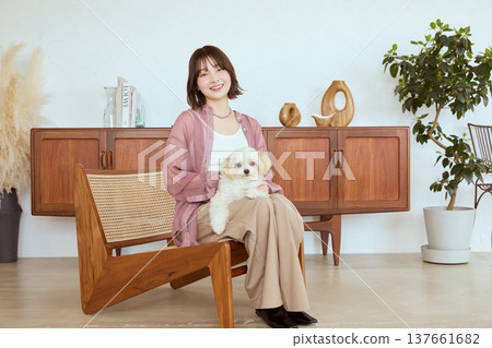 一隻馬爾濟斯犬和一位女士生活在自然風格的室內:寵物生活。 一隻馬爾濟斯犬和一位女士生活在自然風格的室內:寵物生活。 137661682