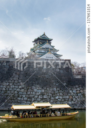 大阪城皇家船及其雄偉的石牆和天守閣的景色。 大阪城皇家船及其雄偉的石牆和天守閣的景色。 137661814