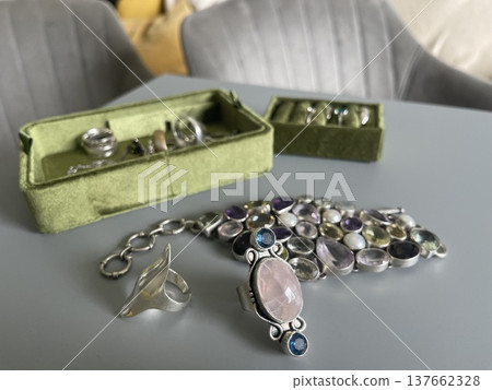 Jewelry collection displayed on a table showing rings and a bracelet with a variety of stones Jewelry collection displayed on a table showing rings and a bracelet with a variety of stones 137662328