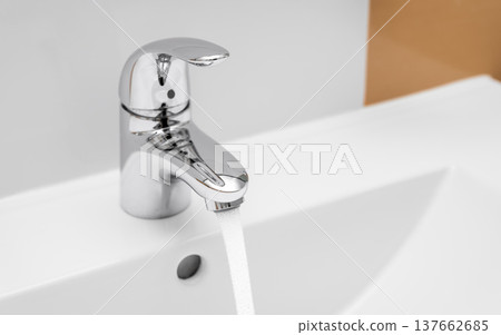Running water from chrome bathroom faucet into sink Running water from chrome bathroom faucet into sink 137662685