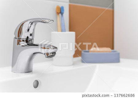 Chrome bathroom faucet with toothbrush and soap on sink 137662686