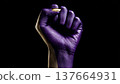 A raised fist painted in purple symbolizes strength and independence, representing feminism and empowerment for women on International Women's Day. 137664931
