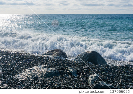 Waves breaking on the pebble beach with rocks Waves breaking on the pebble beach with rocks 137666035