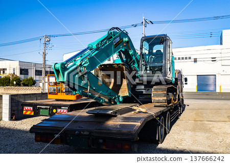 一台重型挖土機被裝載到卡車拖車上。 137666242