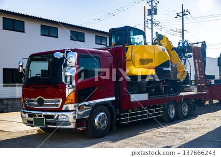 一台重型挖土機被裝載到卡車拖車上。 137666243