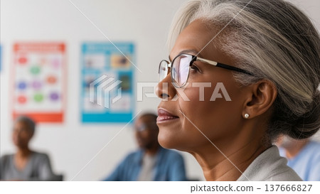 Professional African American businesswoman with glasses looking thoughtfully at presentation charts in modern office meeting room 137666827