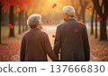 Senior asian couple holding hands walking together in autumn park with falling maple leaves golden hour romantic elderly love lifestyle 137666830