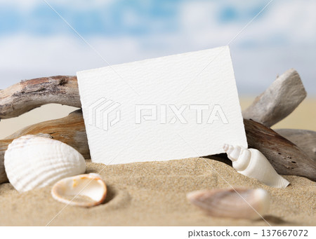 Mockup of blank card on beige sand with seashells, template for beach wedding and event graphics Mockup of blank card on beige sand with seashells, template for beach wedding and event graphics 137667072