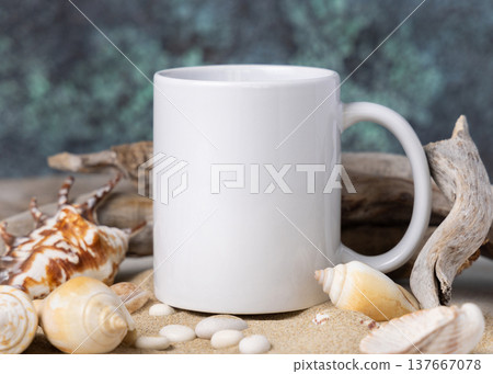 Coffee mug mockup, white blank ceramic mug on sand with seashells and driftwood, copy space 137667078