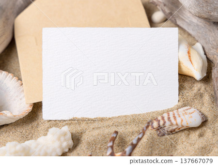 Blank card mockup on sand with seashells and driftwood, beach wedding and summer event invitation 137667079