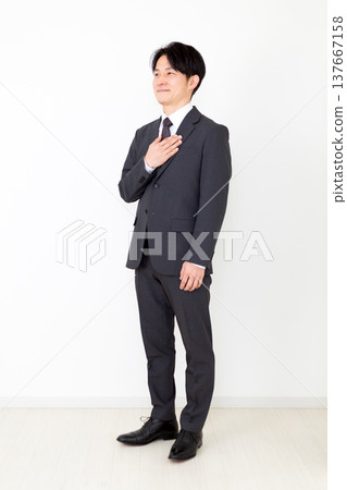 Middle-aged male businessman in a suit holding his hand on his chest 137667158
