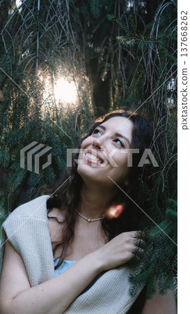 Portrait of a very beautiful young woman in a summer spruce forest at sunset. Portrait of a very beautiful young woman in a summer spruce forest at sunset. 137668262