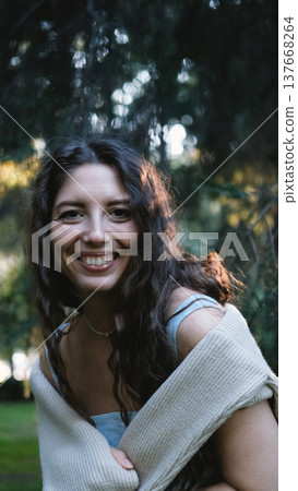 Portrait of a very beautiful young woman in a summer spruce forest at sunset. 137668264