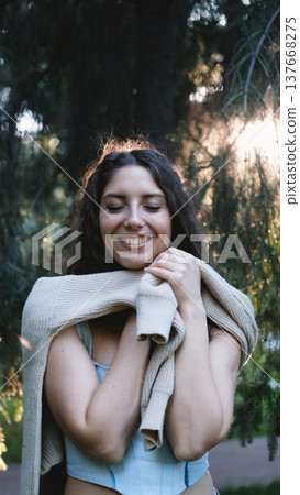 Portrait of a very beautiful young woman in a summer spruce forest at sunset. 137668275