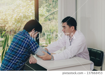 Doctor measuring blood pressure of the patient in the hospital, Medical and health care concepts. Doctor measuring blood pressure of the patient in the hospital, Medical and health care concepts. 137668453