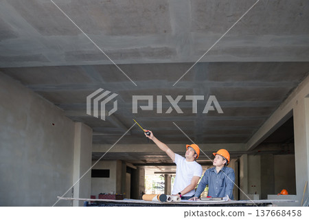 Confident team of architect working together in building construction site. They discussing about new startup project. Architect discuss with engineer about project . Architectural concept. Confident team of architect working together in building construction site. They discussing about new startup project. Architect discuss with engineer about project . Architectural concept. 137668458