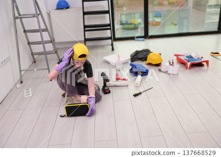 Young builder organizing tools in a bright modern workspace during an exciting renovation project Young builder organizing tools in a bright modern workspace during an exciting renovation project 137668529
