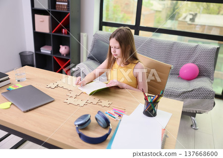 Creative girl immersed in puzzle activity at modern workspace on a sunny afternoon Creative girl immersed in puzzle activity at modern workspace on a sunny afternoon 137668600