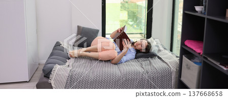 Relaxing at home while reading a captivating story with a cozy atmosphere and a beautiful view of the city outside 137668658