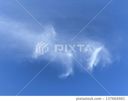 形狀奇特的白色雲朵漂浮在湛藍的天空中 形狀奇特的白色雲朵漂浮在湛藍的天空中 137668981