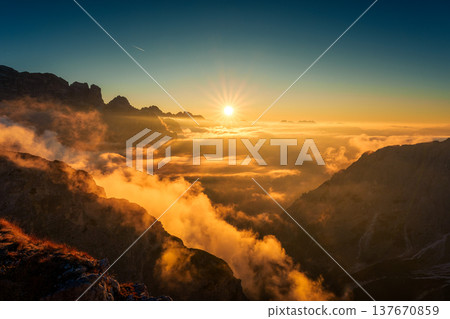 Majestic golden sunrise over mountain ridge and foggy in Cadini di Misurina, Dolomites, Italy 137670859