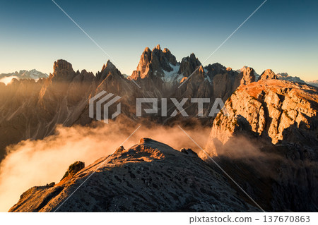 Sunrise shining on Cadini di Misurina peaks and foggy in Dolomites, Italy Sunrise shining on Cadini di Misurina peaks and foggy in Dolomites, Italy 137670863