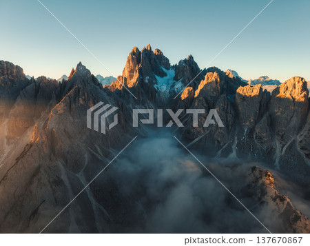 Dramatic Cadini di Misurina mountain peak with fog during sunrise at Dolomites, Italy Dramatic Cadini di Misurina mountain peak with fog during sunrise at Dolomites, Italy 137670867