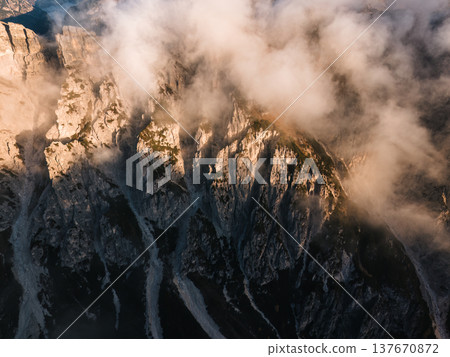 Aerial view golden sunrise over Dolomites rugged mountain peak surrounded by foggy Aerial view golden sunrise over Dolomites rugged mountain peak surrounded by foggy 137670872