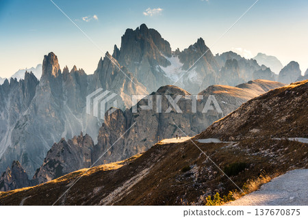 Alpine landscape of Cadini di Misurina mountain peak and hiker walking on mountain pass in Tre Cime di Lavaredo, Dolomites, Italy Alpine landscape of Cadini di Misurina mountain peak and hiker walking on mountain pass in Tre Cime di Lavaredo, Dolomites, Italy 137670875