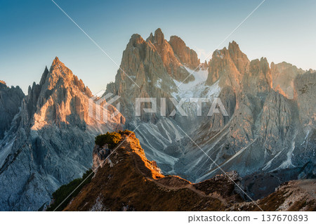 Alpine landscape of Cadini di Misurina with rugged mountain range during sunset in Dolomites, Italy Alpine landscape of Cadini di Misurina with rugged mountain range during sunset in Dolomites, Italy 137670893