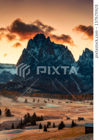 Alpine autumn Alpe di Siusi or Seiser Alm with wooden hut on golden grass hill and Dolomites mountain during morning in Italy 137670928