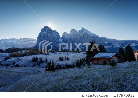 Sunrise over Alpe di Siusi with Dolomites mountain on frosted rolling hill and wooden hut in early morning at Italy Sunrise over Alpe di Siusi with Dolomites mountain on frosted rolling hill and wooden hut in early morning at Italy 137670932