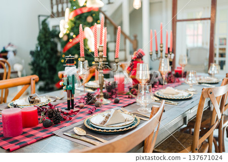 Festive christmas dining table with candles, pinecones, elegant tableware in cozy home interior Festive christmas dining table with candles, pinecones, elegant tableware in cozy home interior 137671024