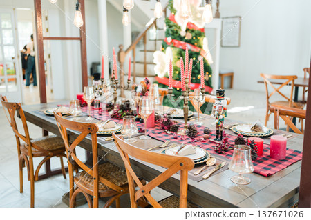 Festive christmas dining table with candles, pinecones, elegant tableware in cozy home interior 137671026