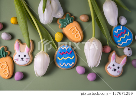 Easter spring holiday background with easter cookies: buny, carrot and egg with white tulip flowers, flat lay Easter spring holiday background with easter cookies: buny, carrot and egg with white tulip flowers, flat lay 137671299
