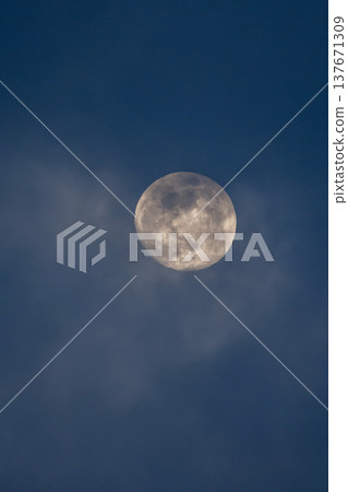Real full moon against a dark blue sky, showing craters and lunar surface, copy space 137671309