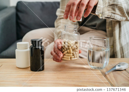 Woman pouring a pile of pills, capsules from bottle in hand. Prescription medication, treatment sickness concept 137671346