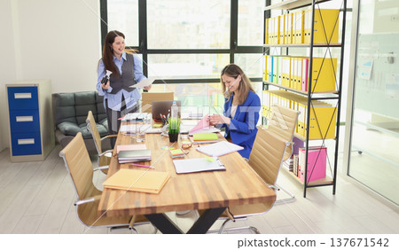 Office teamwork thrives in a bright modern workspace filled with colorful files and productive energy during a busy workday 137671542