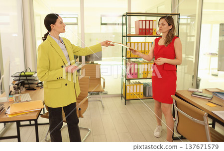Business meeting in a bright office with two professionals discussing important documents and ideas during a workday 137671579